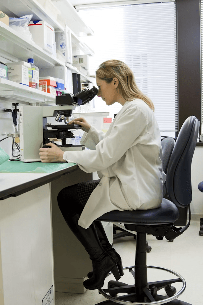 Scientist examining samples through a laboratory microscope